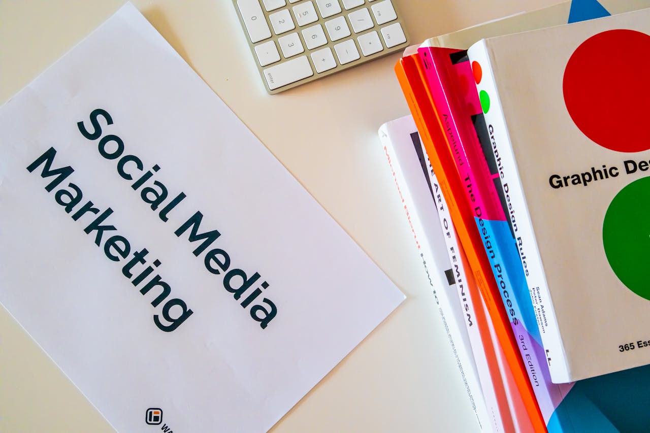 home-services-02 A top view of social media marketing text alongside graphic design books and a keyboard.